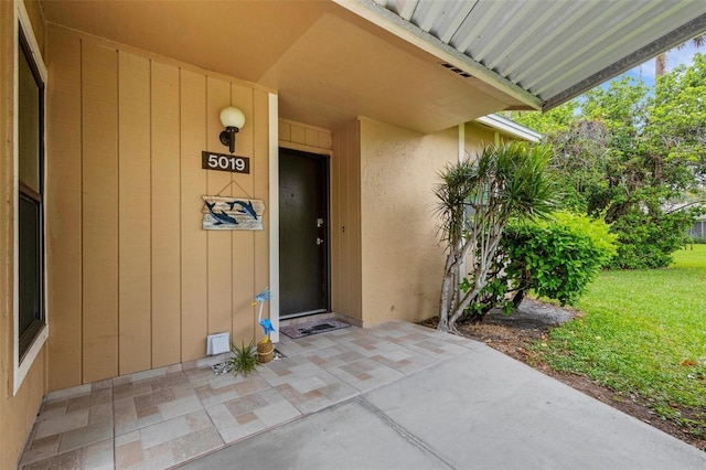 doorway to property with visible vents, a patio, and a yard