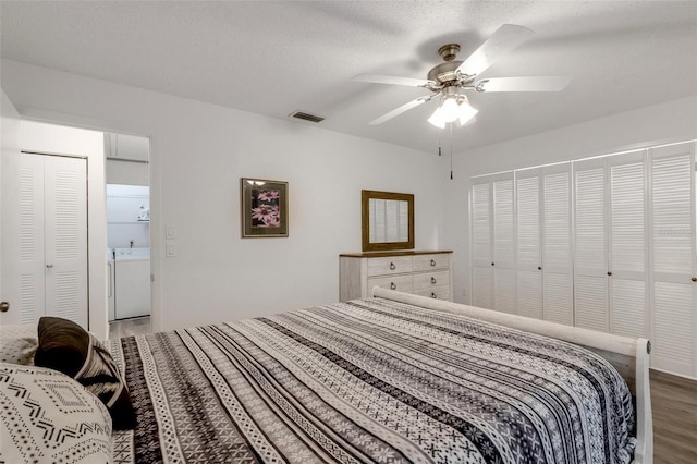 bedroom featuring light wood-type flooring, visible vents, washer / clothes dryer, a textured ceiling, and ceiling fan