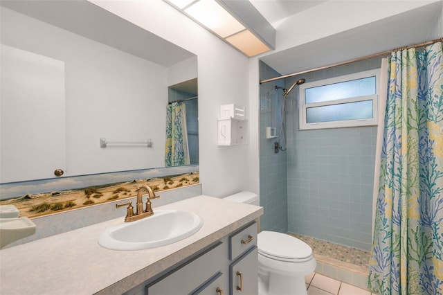 bathroom with vanity, toilet, tile patterned flooring, and tiled shower