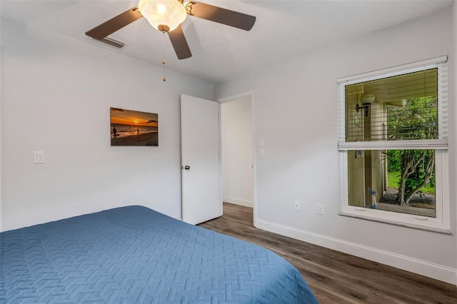 unfurnished bedroom with visible vents, wood finished floors, baseboards, and ceiling fan