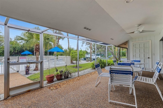 sunroom / solarium with visible vents, a ceiling fan, and vaulted ceiling