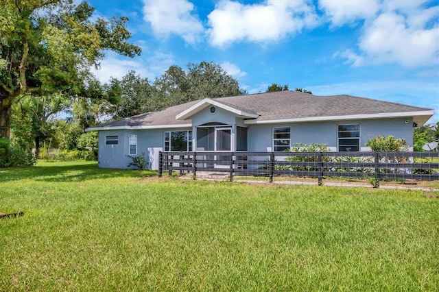 view of front of house featuring a front yard, fence, and stucco siding