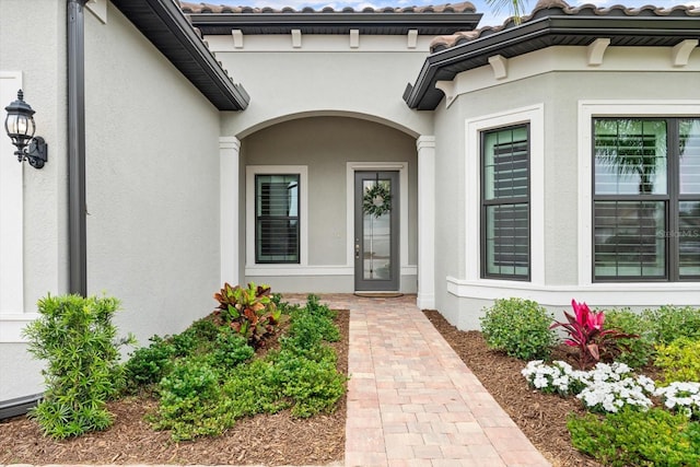 entrance to property featuring stucco siding and a tile roof