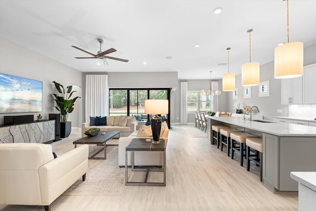 living room featuring recessed lighting, baseboards, a ceiling fan, and light wood finished floors