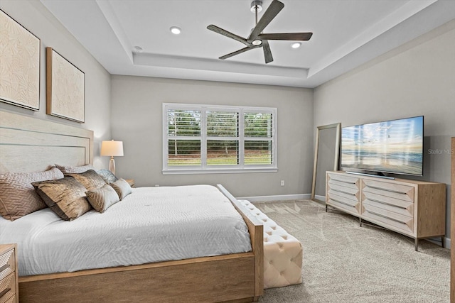 carpeted bedroom featuring recessed lighting, baseboards, a tray ceiling, and ceiling fan