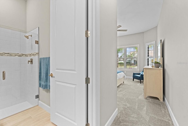 bathroom with a shower stall, baseboards, and connected bathroom