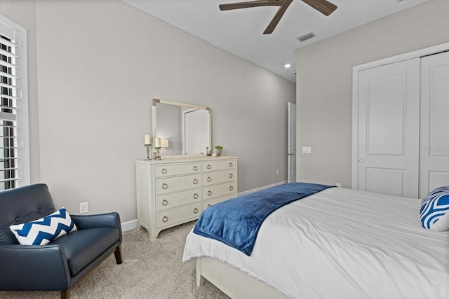 bedroom featuring visible vents, baseboards, light carpet, a closet, and a ceiling fan