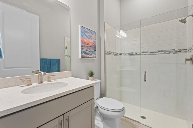 full bathroom featuring toilet, a stall shower, and vanity