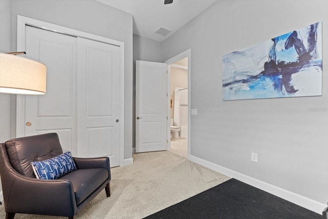 living area with visible vents, baseboards, and carpet