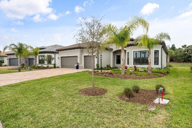 view of front facade featuring a front lawn, a tiled roof, decorative driveway, and an attached garage