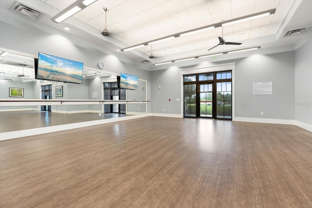 interior space with wood finished floors, a ceiling fan, visible vents, and baseboards