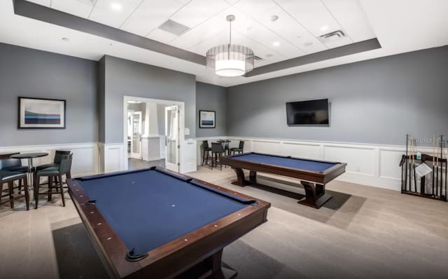 game room featuring pool table, a tray ceiling, a decorative wall, and visible vents