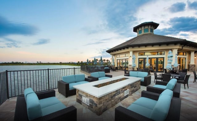 view of patio / terrace with a water view and an outdoor living space with a fire pit