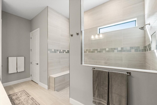 bathroom featuring a walk in shower, baseboards, and tile patterned floors