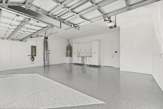 garage featuring concrete block wall, a garage door opener, water heater, and electric panel