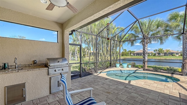 exterior space with glass enclosure, a water view, a sink, exterior kitchen, and grilling area