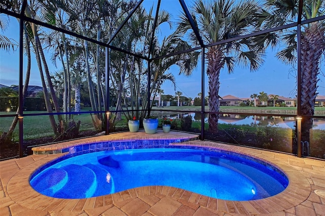 view of swimming pool with a patio area, glass enclosure, a water view, and a swimming pool