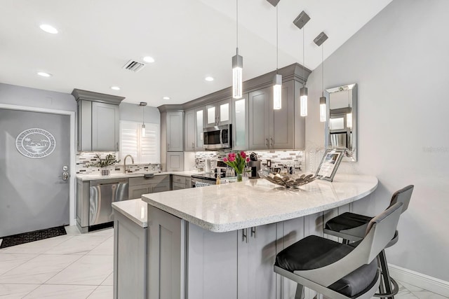 kitchen featuring gray cabinetry, stainless steel appliances, a peninsula, visible vents, and marble finish floor