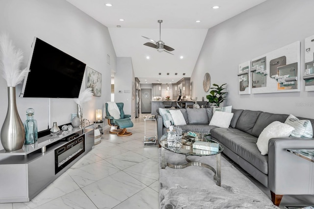 living area with a ceiling fan, recessed lighting, marble finish floor, and high vaulted ceiling