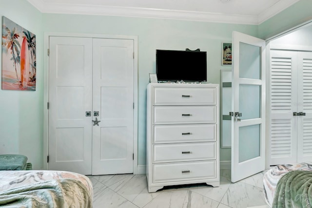 bedroom with ornamental molding, marble finish floor, and a closet