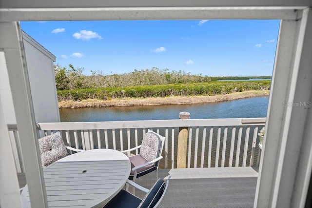 balcony with a water view and outdoor dining space