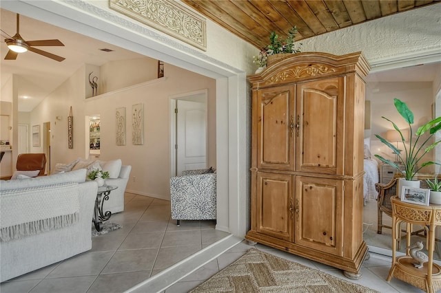 interior space featuring tile patterned flooring, visible vents, lofted ceiling, wooden ceiling, and a ceiling fan