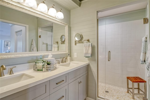 full bath featuring double vanity, a stall shower, and a sink