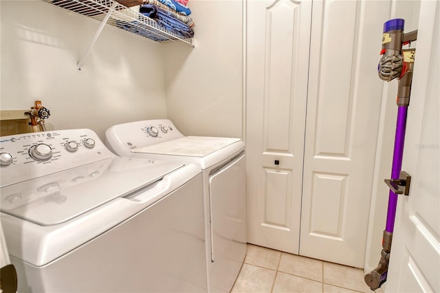 washroom with washer and dryer, laundry area, and light tile patterned floors