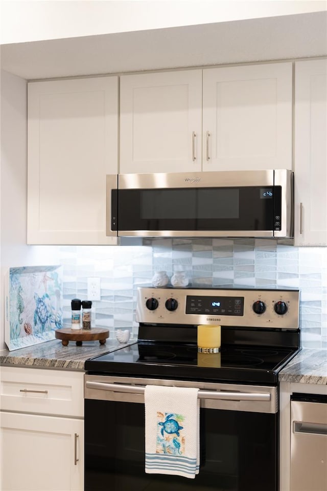 kitchen with appliances with stainless steel finishes, backsplash, and white cabinetry