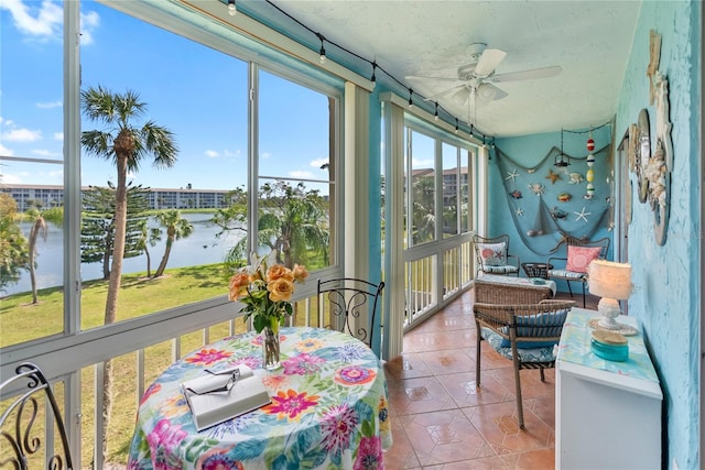 sunroom with a water view and a ceiling fan