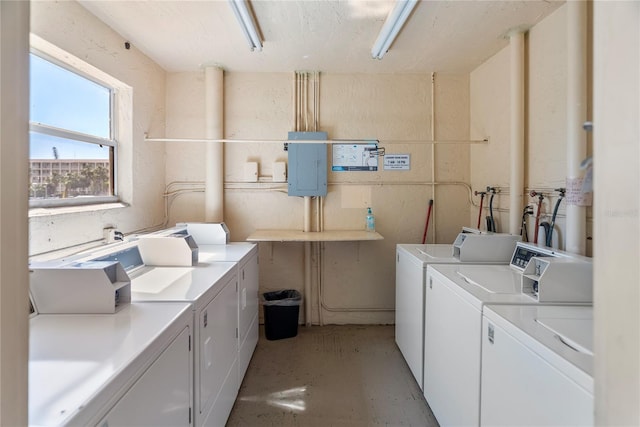 community laundry room featuring electric panel and separate washer and dryer