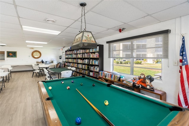 playroom with a paneled ceiling, visible vents, and wood finished floors