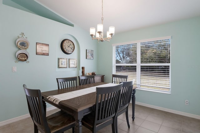 dining area with vaulted ceiling, light tile patterned floors, baseboards, and a notable chandelier