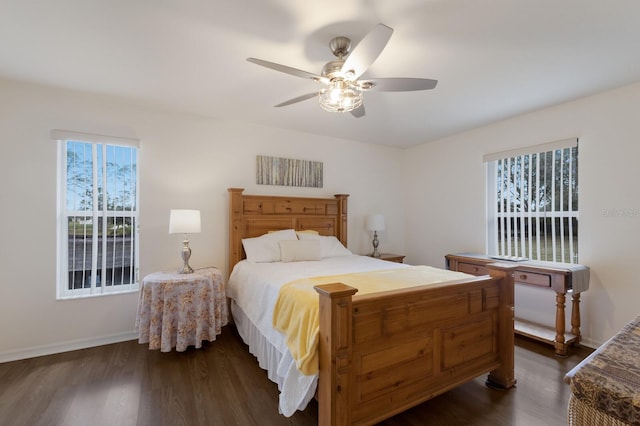 bedroom featuring baseboards, dark wood finished floors, and a ceiling fan