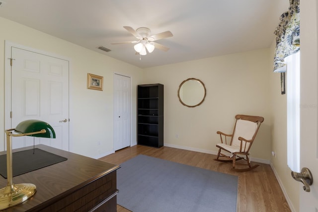 office area featuring a ceiling fan, baseboards, visible vents, and wood finished floors