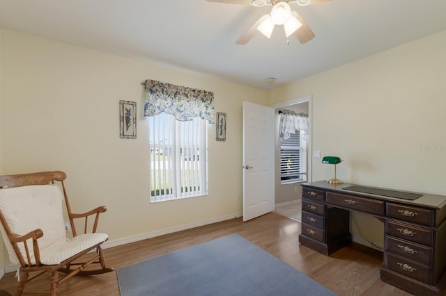 home office with dark wood-type flooring, ceiling fan, and baseboards