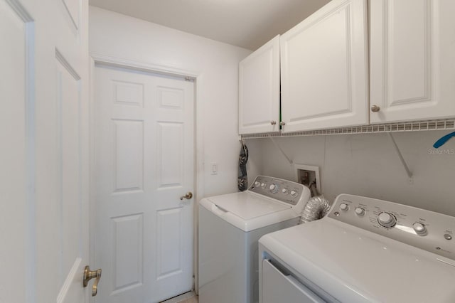 clothes washing area with washing machine and clothes dryer and cabinet space