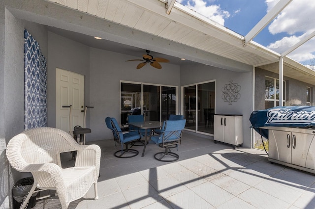 view of patio / terrace with a lanai, a ceiling fan, and outdoor dining space