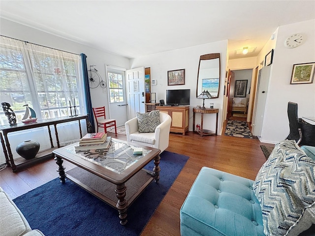 living area with baseboards and wood finished floors