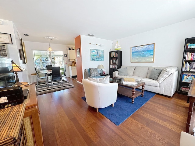 living room featuring visible vents and dark wood-type flooring