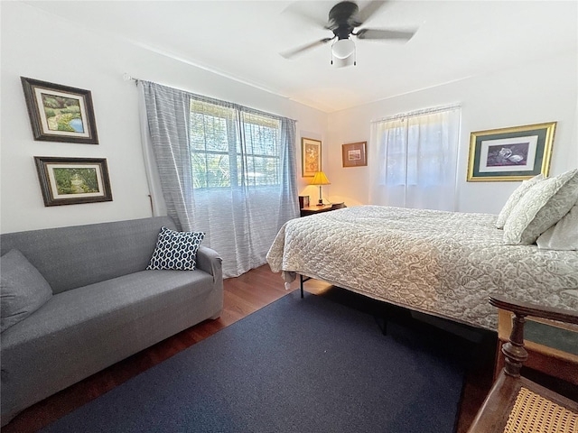 bedroom with multiple windows, a ceiling fan, and wood finished floors