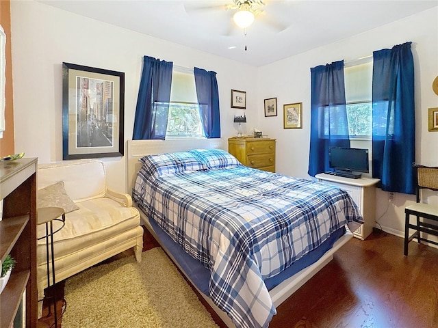 bedroom with ceiling fan, baseboards, and wood finished floors