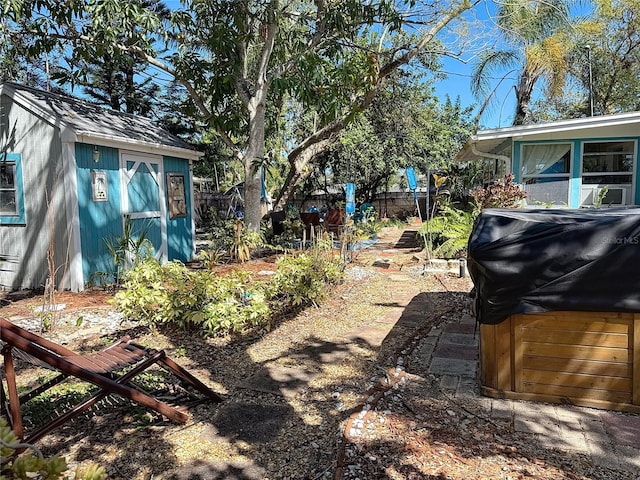 view of yard featuring a storage unit, an outdoor structure, and fence