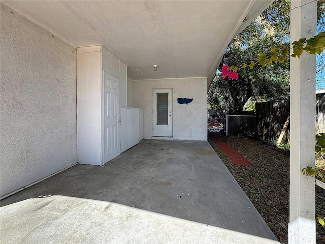 property entrance with fence and stucco siding