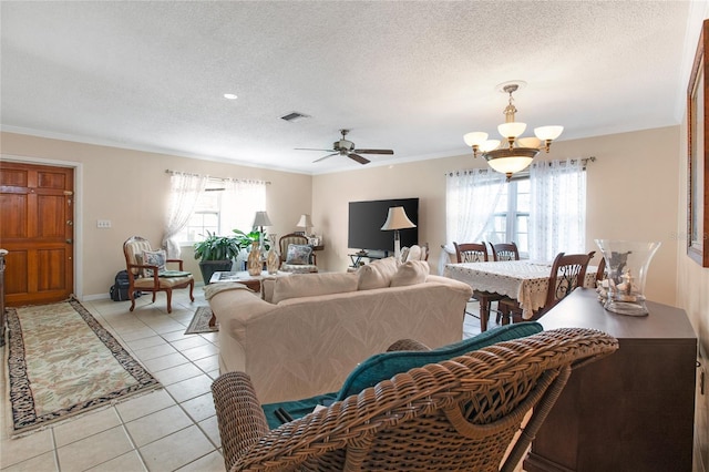 living room with light tile patterned floors, a wealth of natural light, a textured ceiling, and visible vents