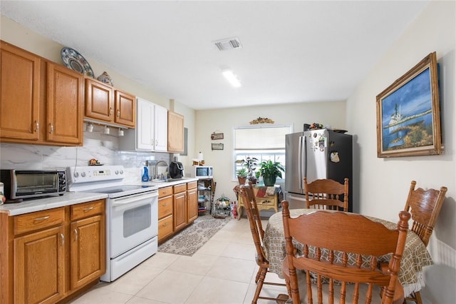 kitchen with a toaster, white appliances, visible vents, light countertops, and tasteful backsplash