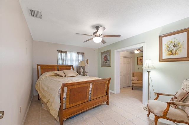 bedroom with light tile patterned floors, baseboards, visible vents, ceiling fan, and a textured ceiling