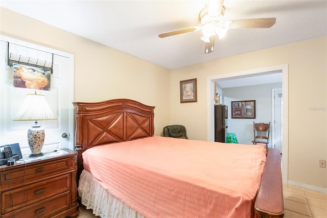 bedroom with ceiling fan, baseboards, and light tile patterned flooring