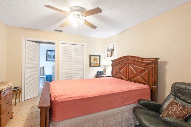 bedroom featuring visible vents, ceiling fan, a textured ceiling, and light tile patterned floors