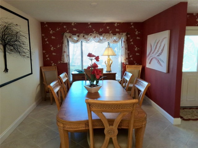 dining area with light tile patterned floors, baseboards, and wallpapered walls